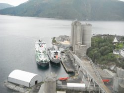 Looking from the pre-heater tower towards the cement silos and domestic wharf. The vessel on the left is supplying fly ash and the vessel on the right is a cement delivery vessel chartered for the summer. In the extreme lower left, the RDF pellet storage facility highlights the lack of space on the site.
