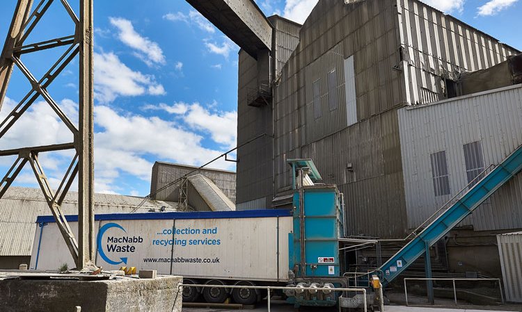 SRF walking floor trailers docked to a Schenck Process screw and conveyor based feeding system.