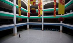 A solitary man walks through part of the New South China Mall. Built in an industrial city with little disposable income, the mall has attracted only a small numbers of shoppers.