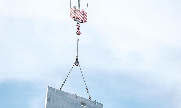 Alternative raw materials-based precast concrete moving into place at a construction site. Photo credit: Elvir K via Unsplash and ALCCC.