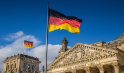 German flags waving in the wind at famous Reichstag building. Source: Shutterstock.